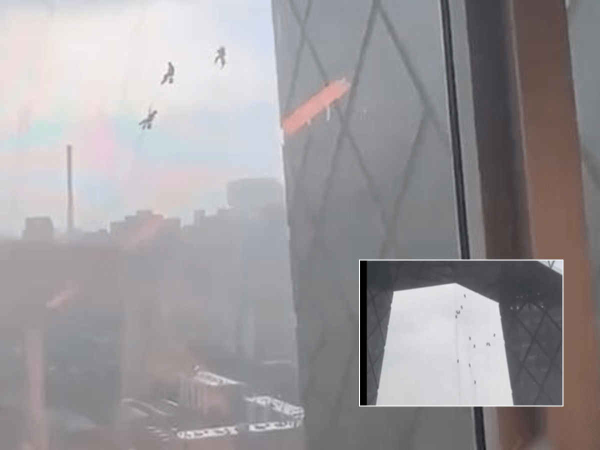 Maintenance Workers Hang from Building Amidst Beijing's Strong Winds